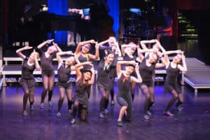 Young actors wearing black dancing on stage
