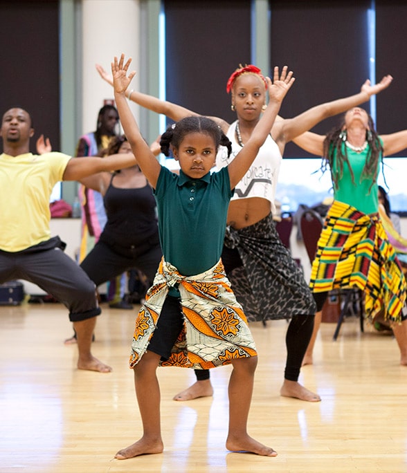 student poses in still stance with arms stretched out.