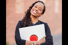 Paige Hernandez holding vinyl record and smiling