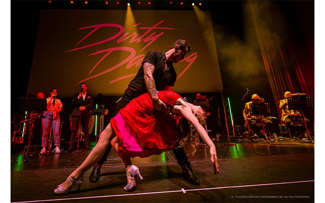 Dancers and Band on Stage in front of Dirty Dancing Logo