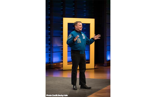 Terry Virts on Stage in front of National Geographic Physical Logo