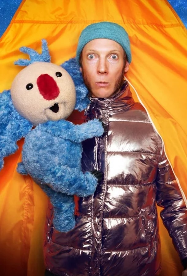 A man wearing blue hat with rose gold snow suit and a blue stuffed koala hugging the man