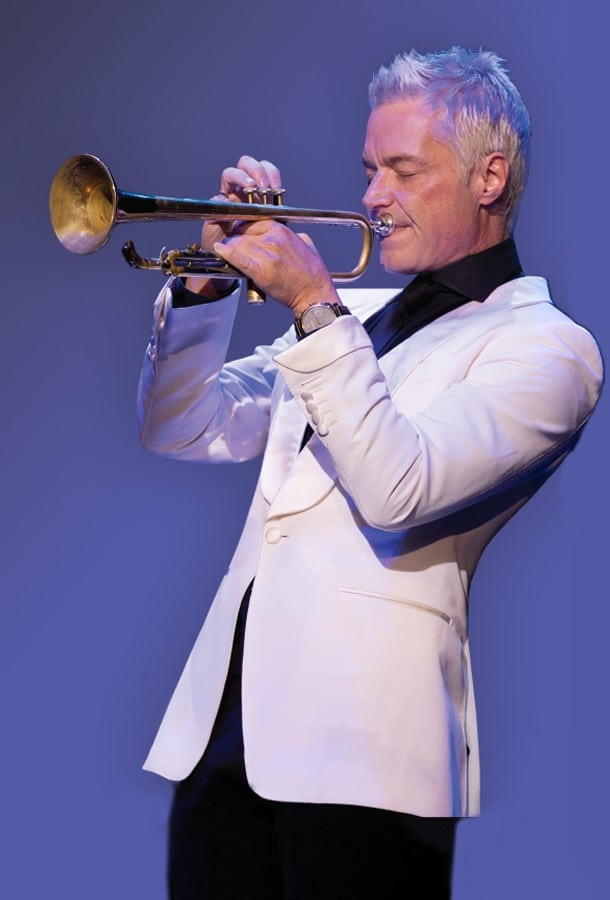 Chris Botti playing trumpet in white suit.