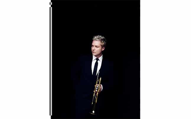 Chris Botti holding his trumpet in Suit and Tie
