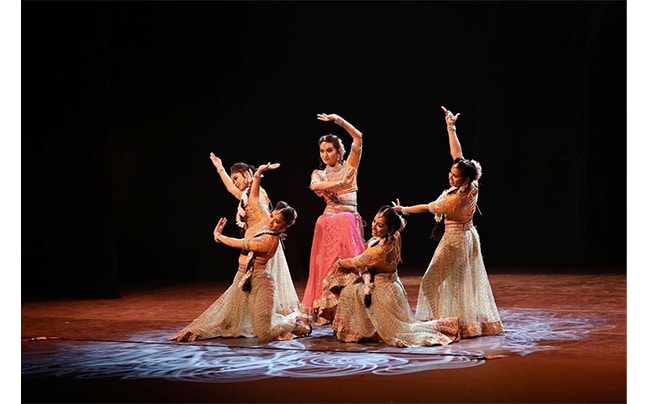 Five Women on stage in dresses posing