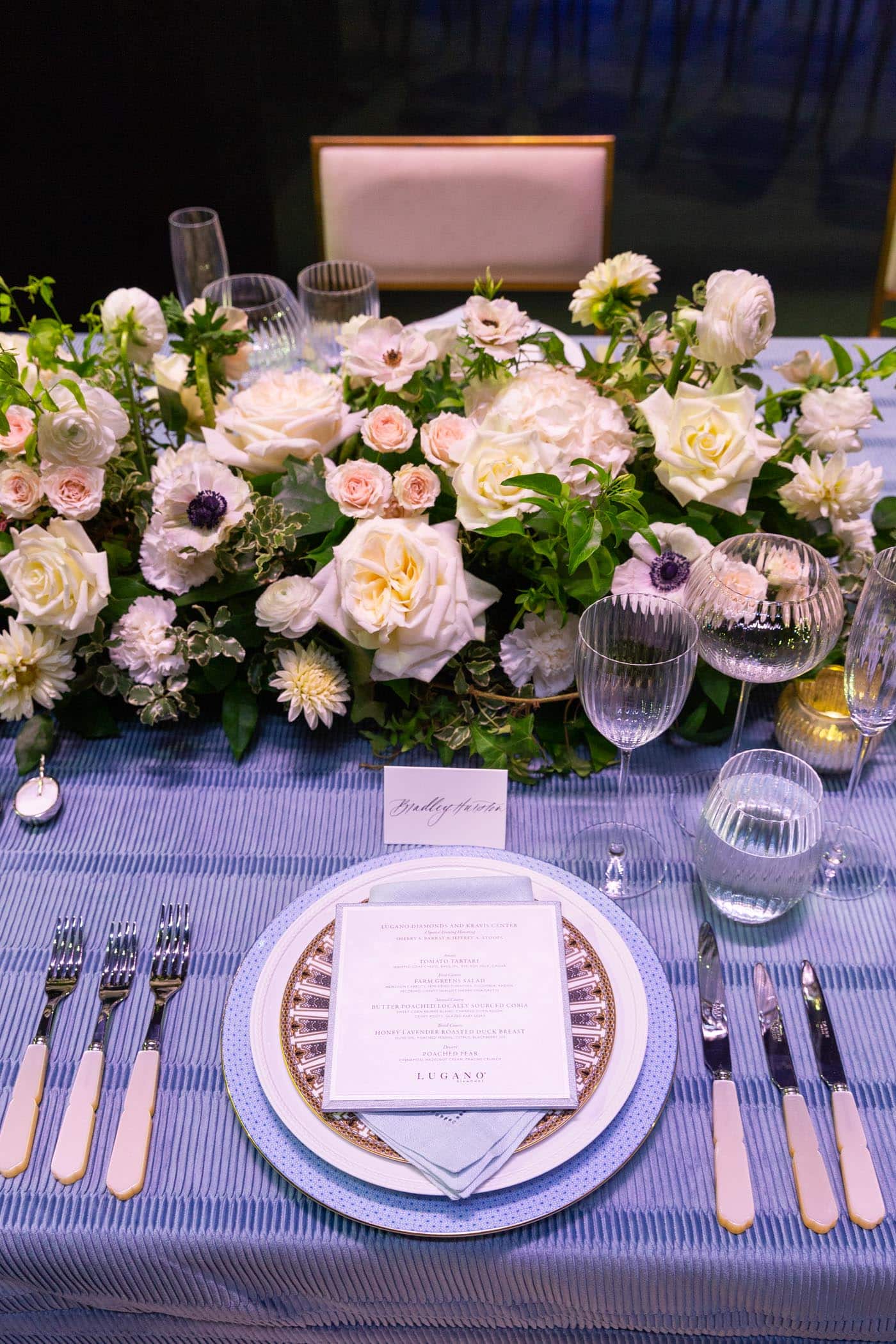 Table setting featuring menu and floral arrangement.