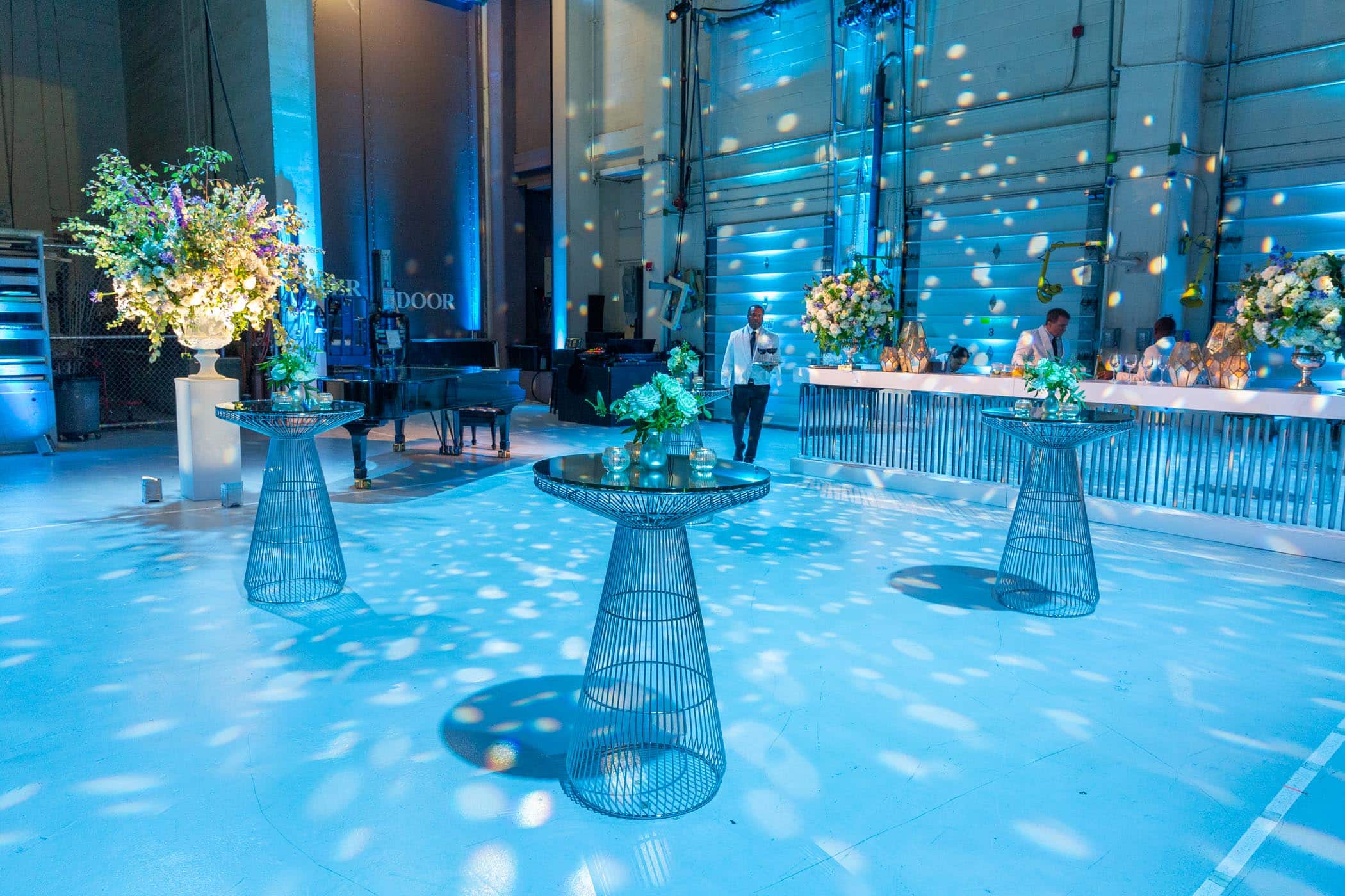 Cocktail tables set up in blue lighting.
