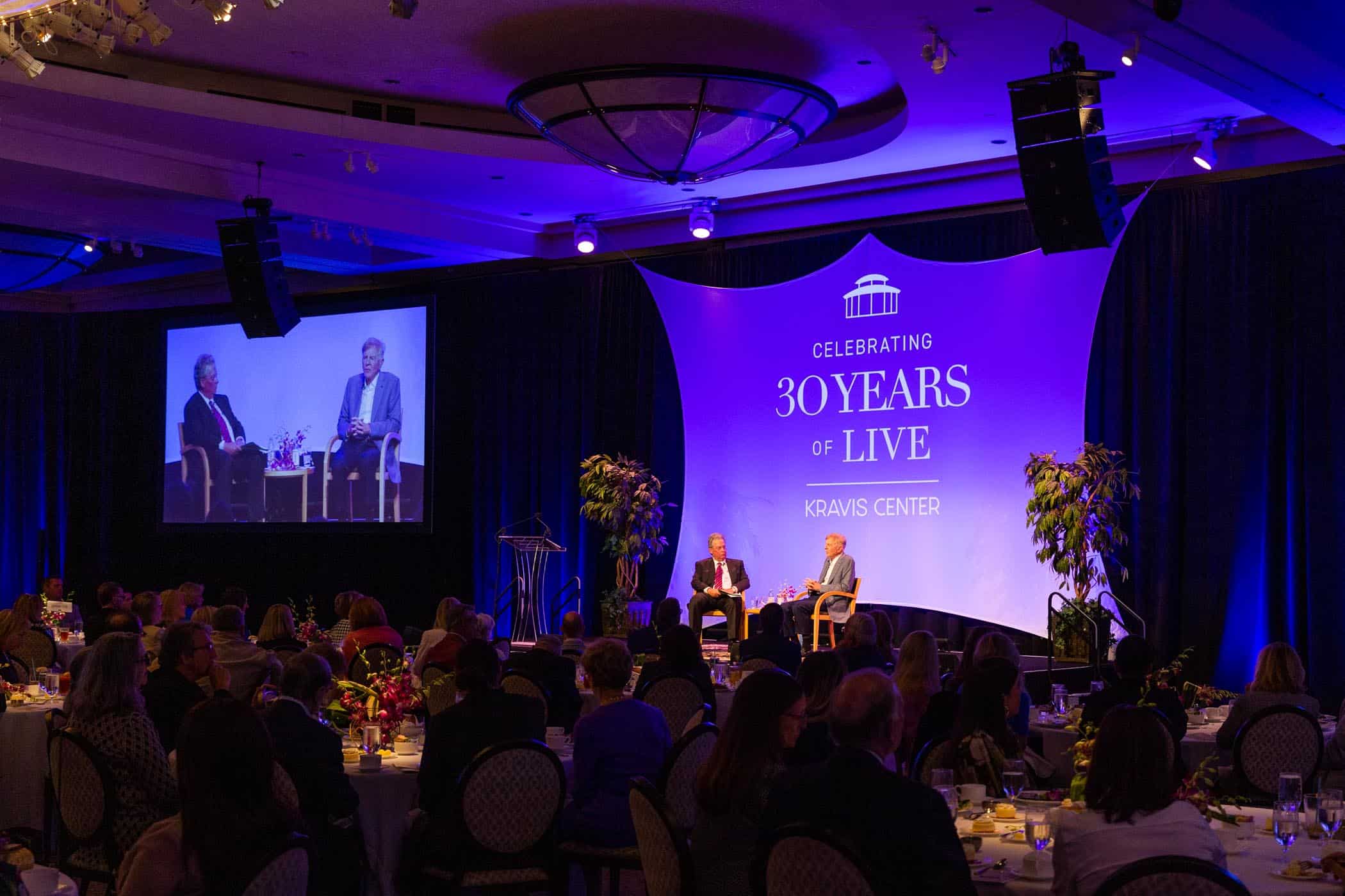 Picture of luncheon room facing stage featuring 30th anniversary logo