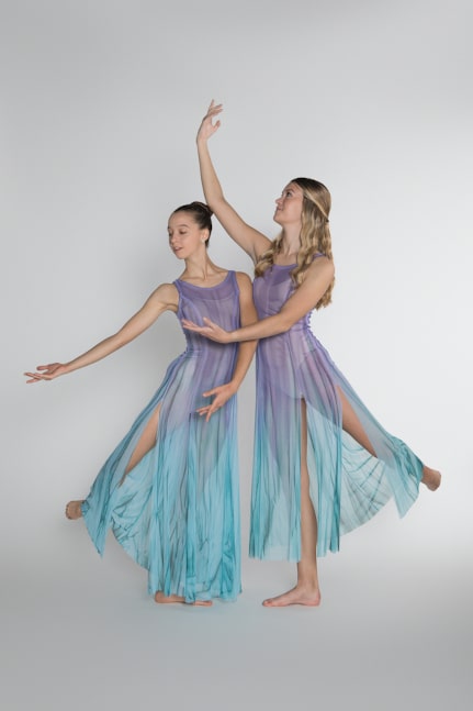 Two dancers in blue colored attire posing