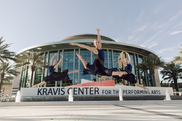 dancers leap in front of Kravis Center plaza.