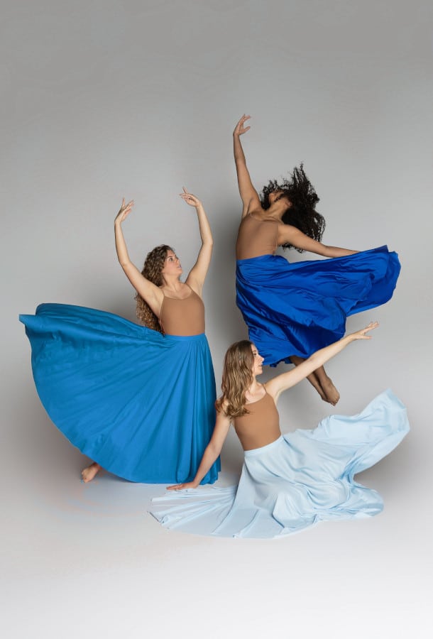 three girls in blue dance dresses posing.