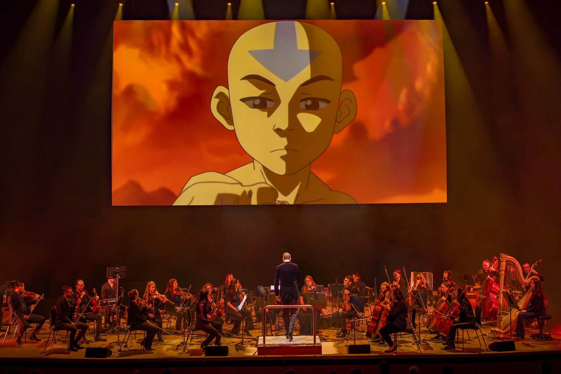 Avatar Concert on stage with orchestra. Large screen playing series