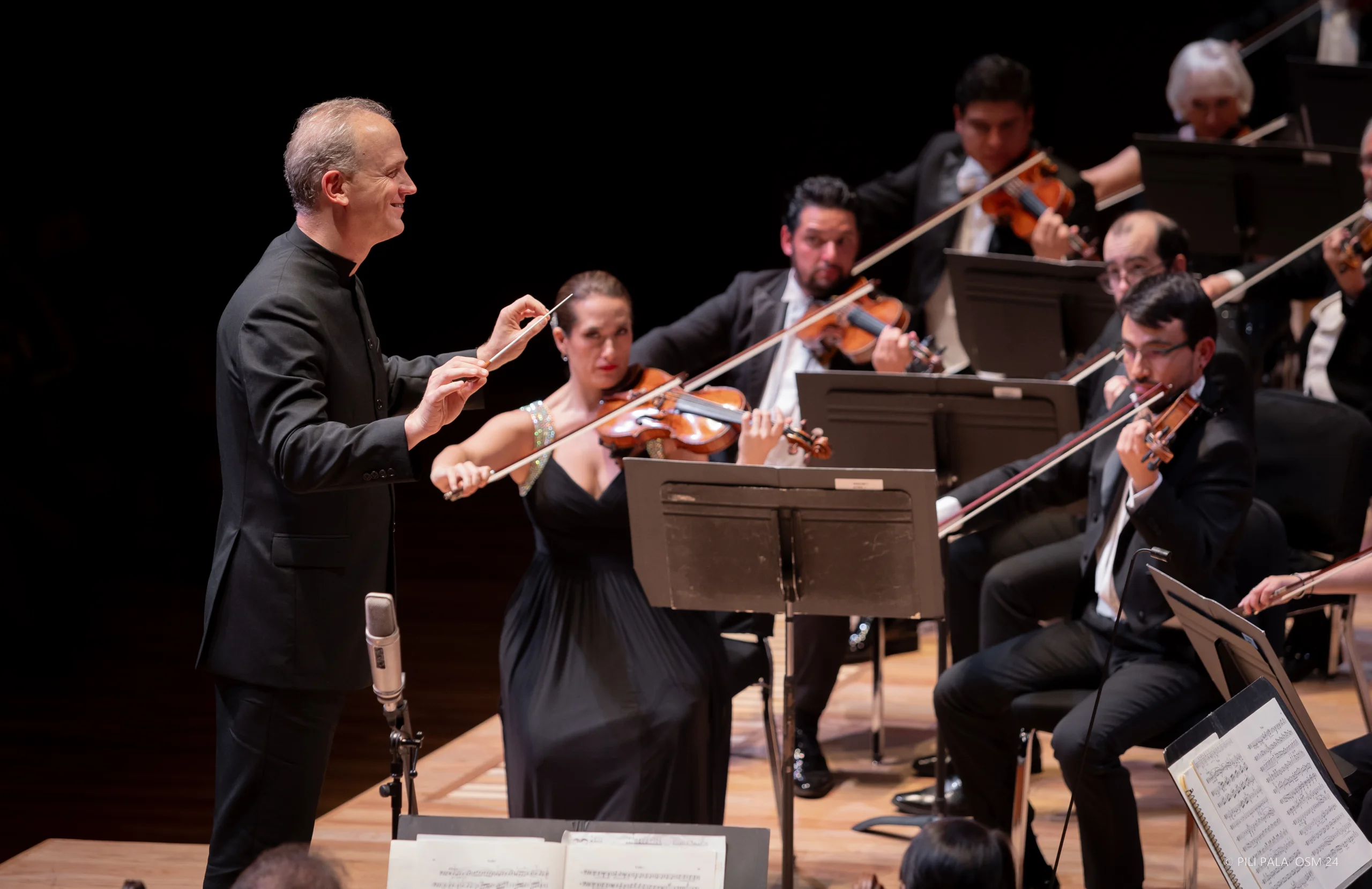 Carlos Miguel Prieto with the orchestra conducting.