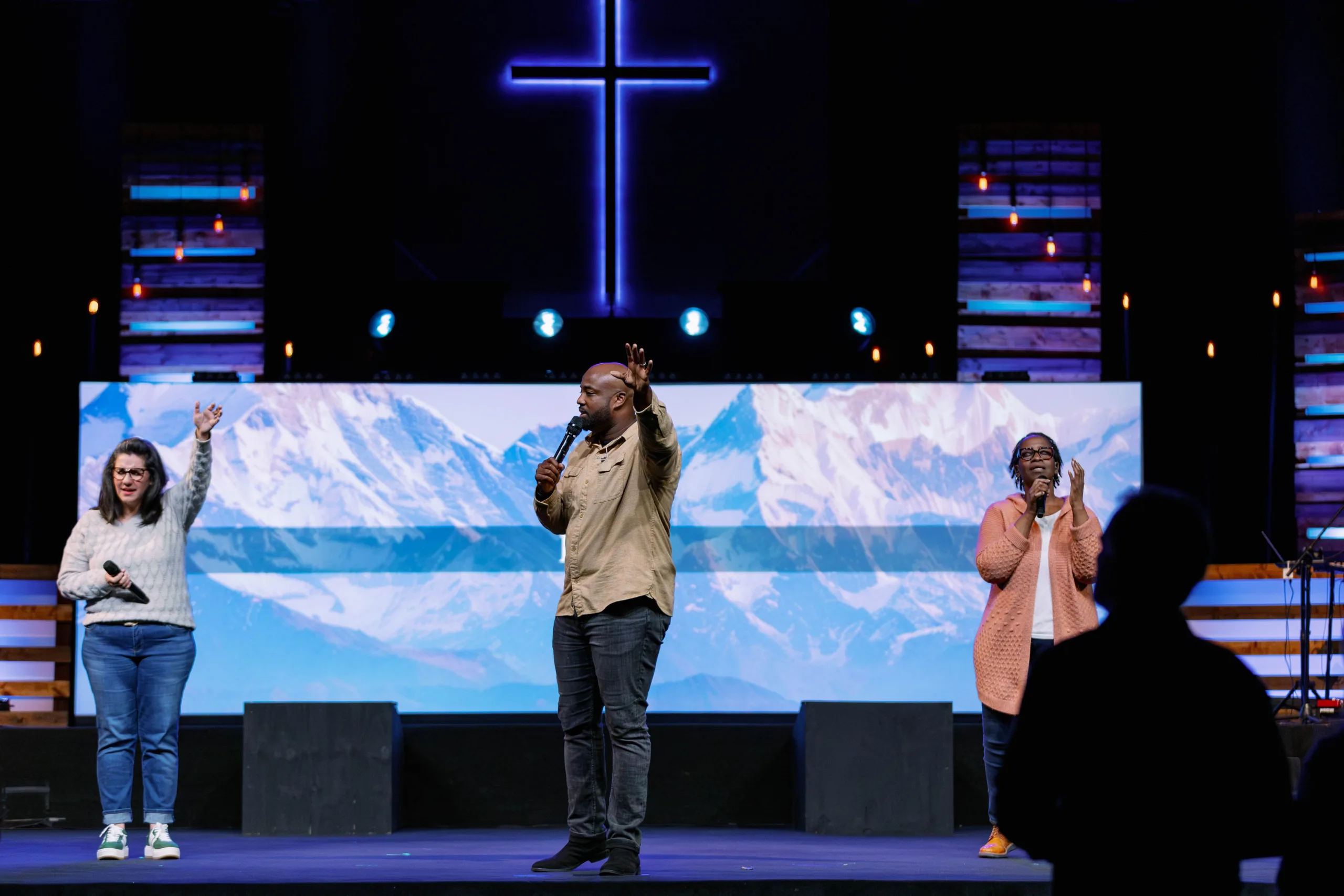 man and women singing on stage.