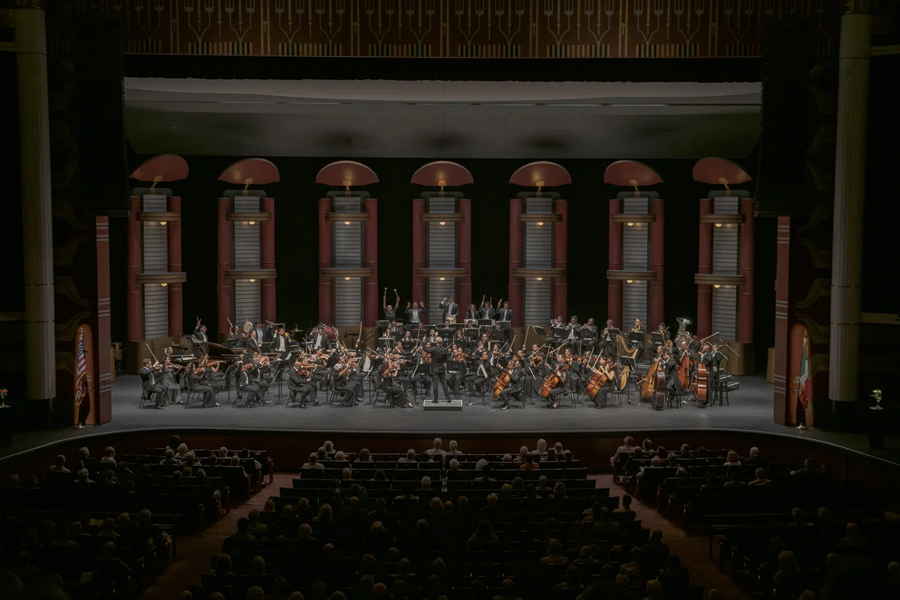 Orchestra performs on stage.