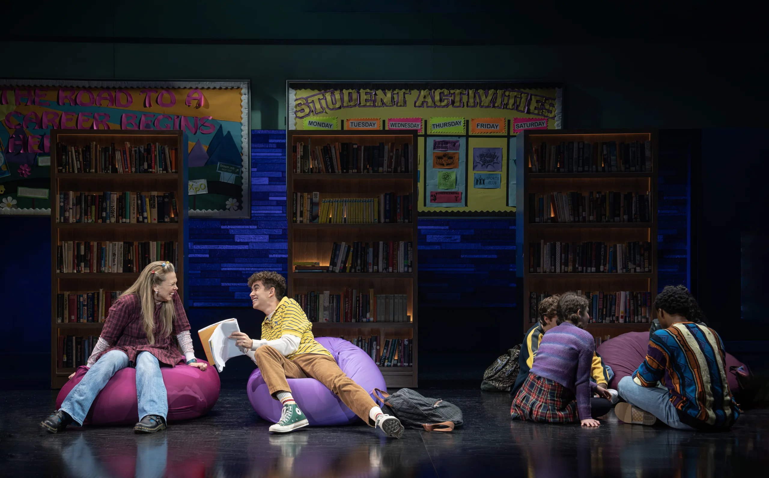 Students sitting on bean bags showing each other books. 