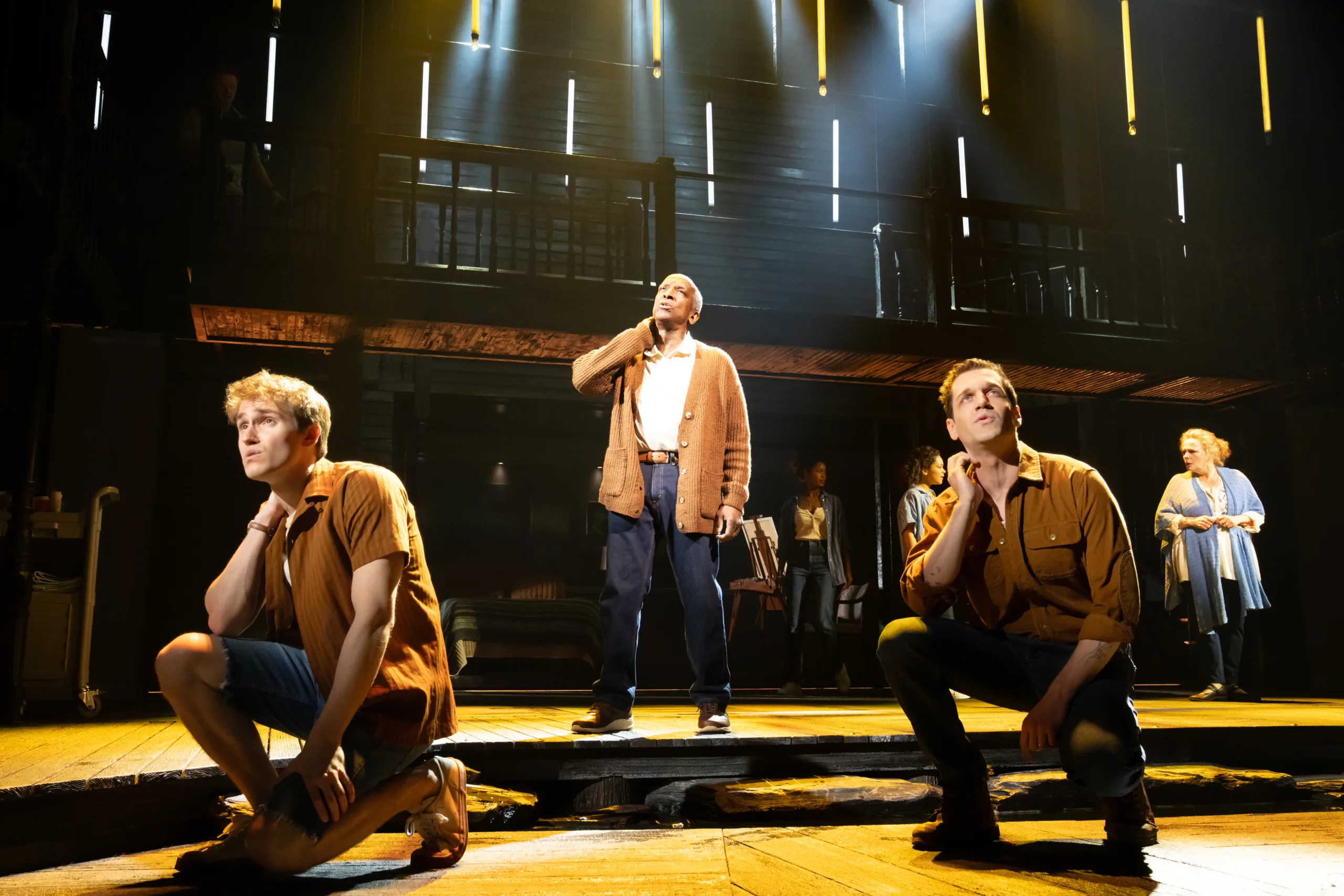 All three ages of Noah on stage together with two of them kneeling in the front and the other standing. 