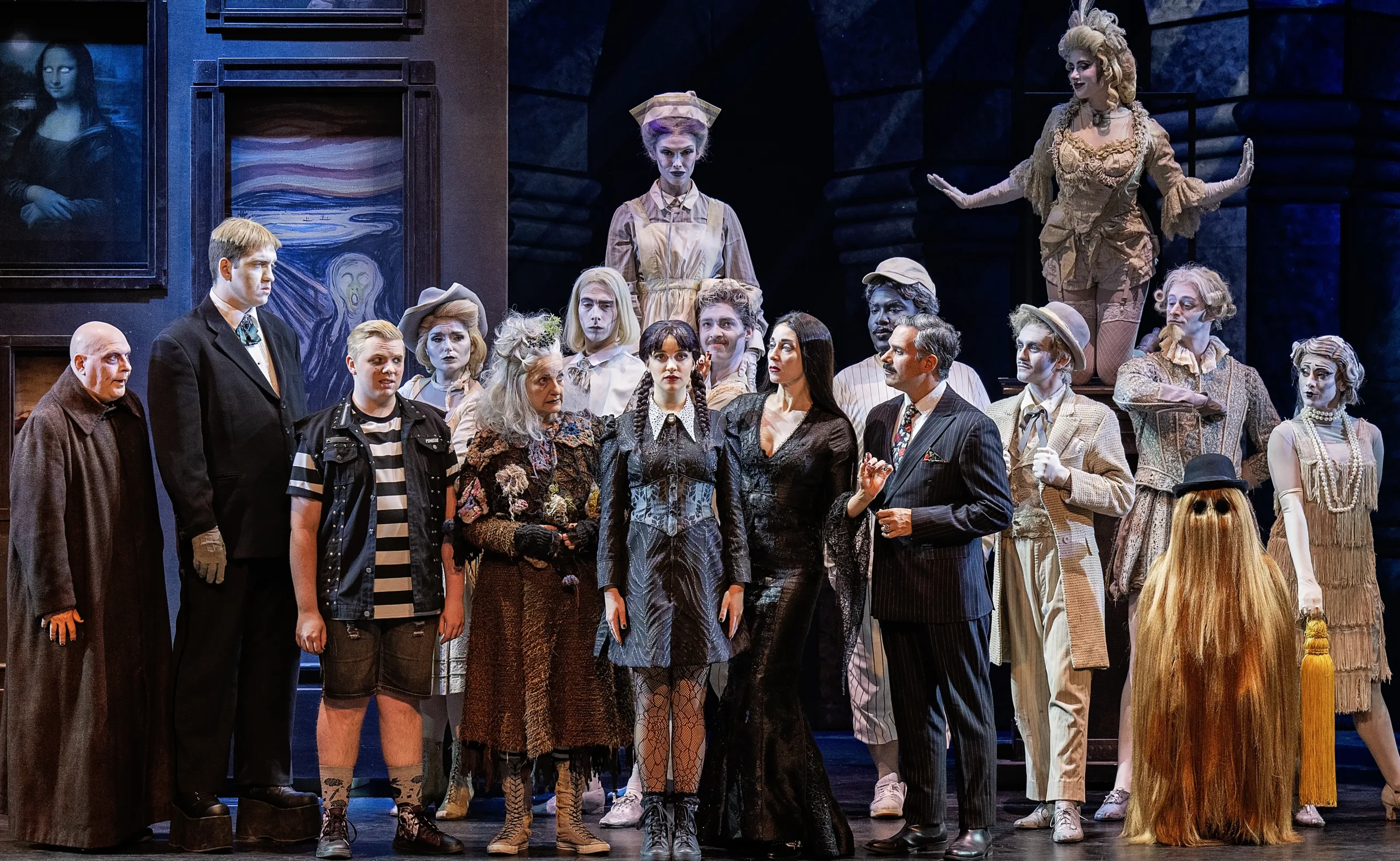 The whole Addams family including the Ancestors in a group on stage.