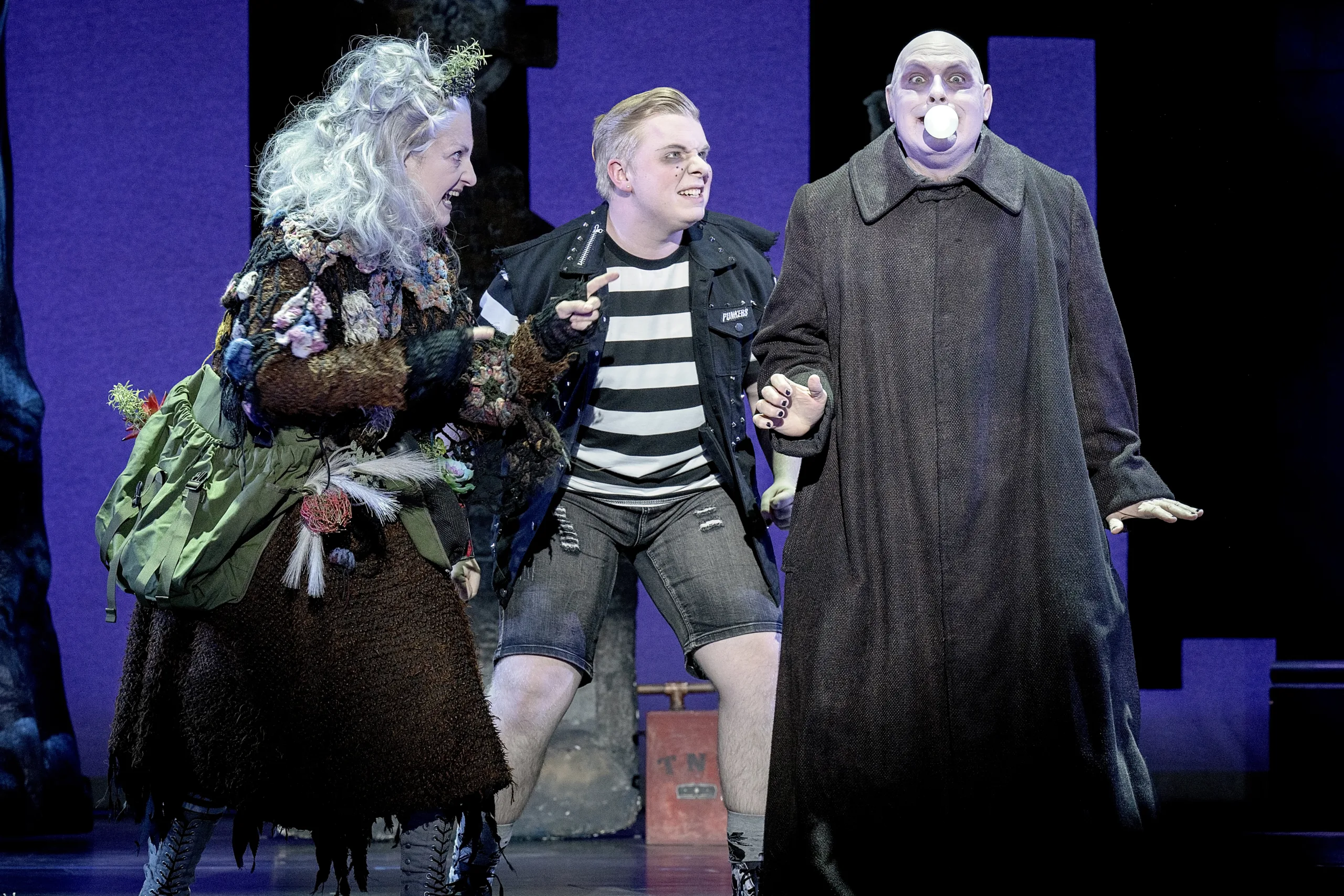 Grandma Addams, Pugsley and Uncle Fester standing together.