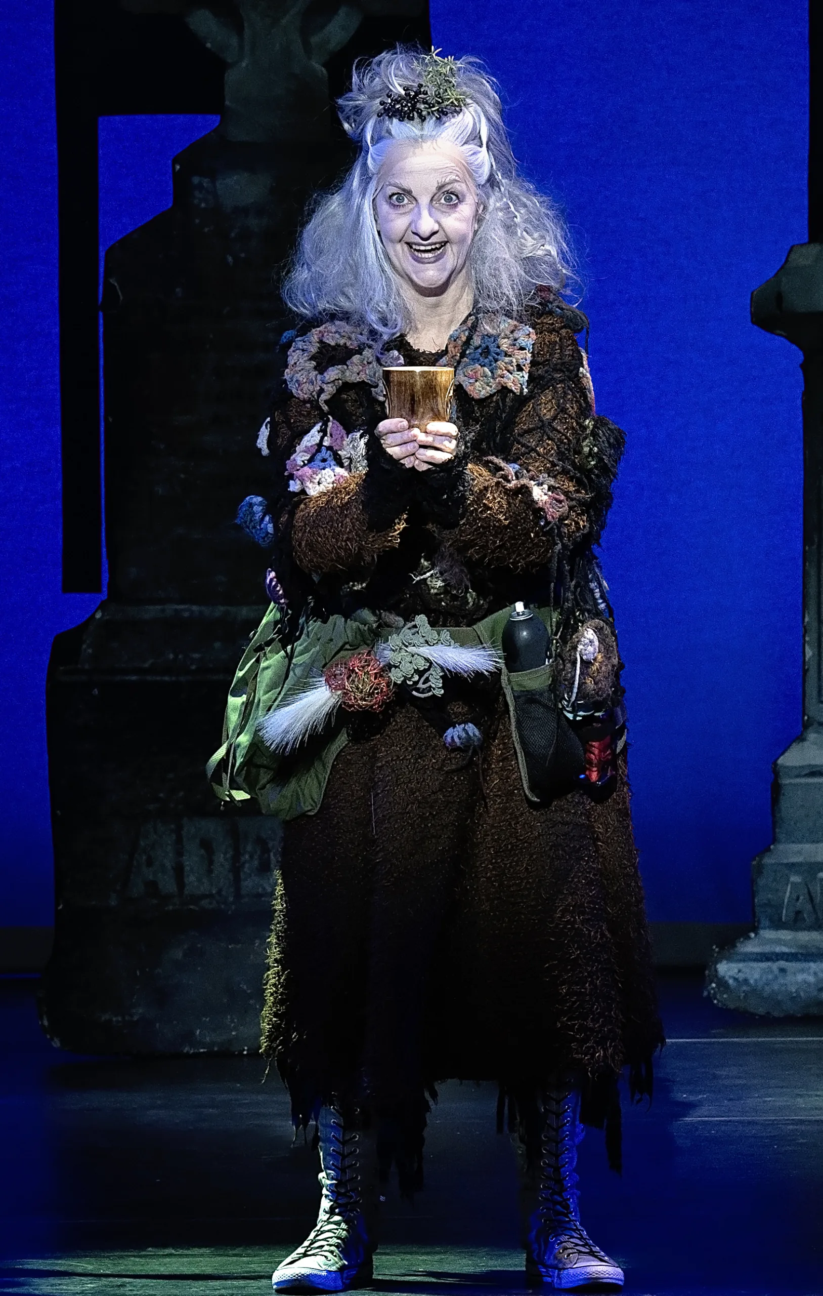Grandma Addams holding a goblet. 