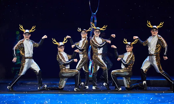 Six performers dressed as sparkling reindeer posing. 