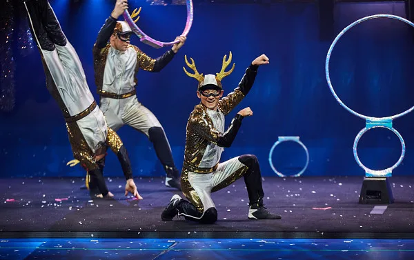 Three performers dressed as Reindeer doing tricks. 