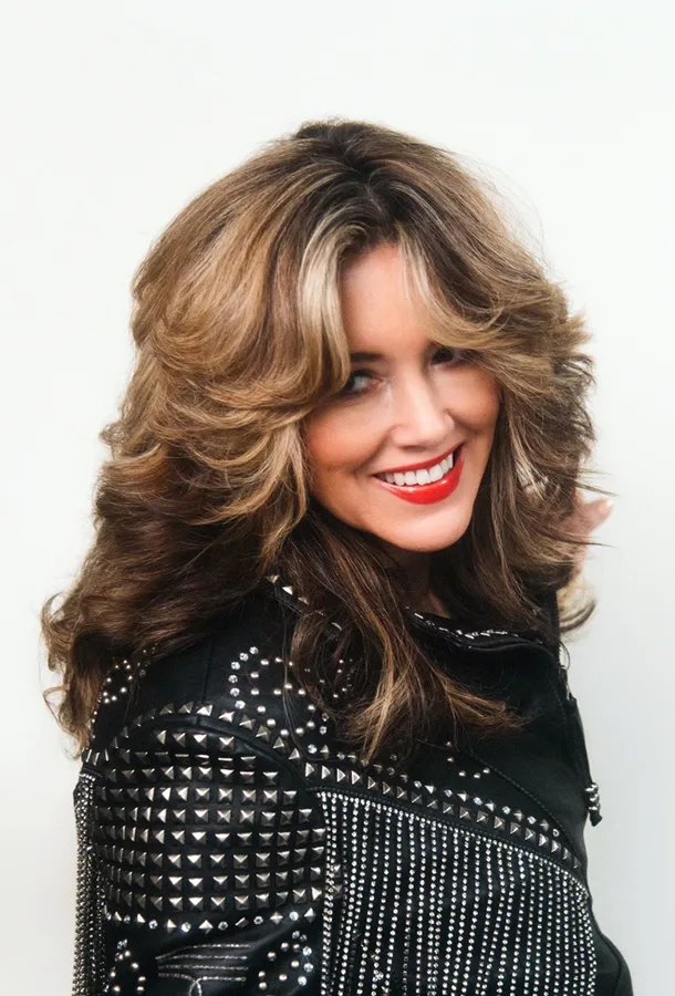 Mandy Barnett headshot wearing black jacket and smiling over her right shoulder toward the camera.