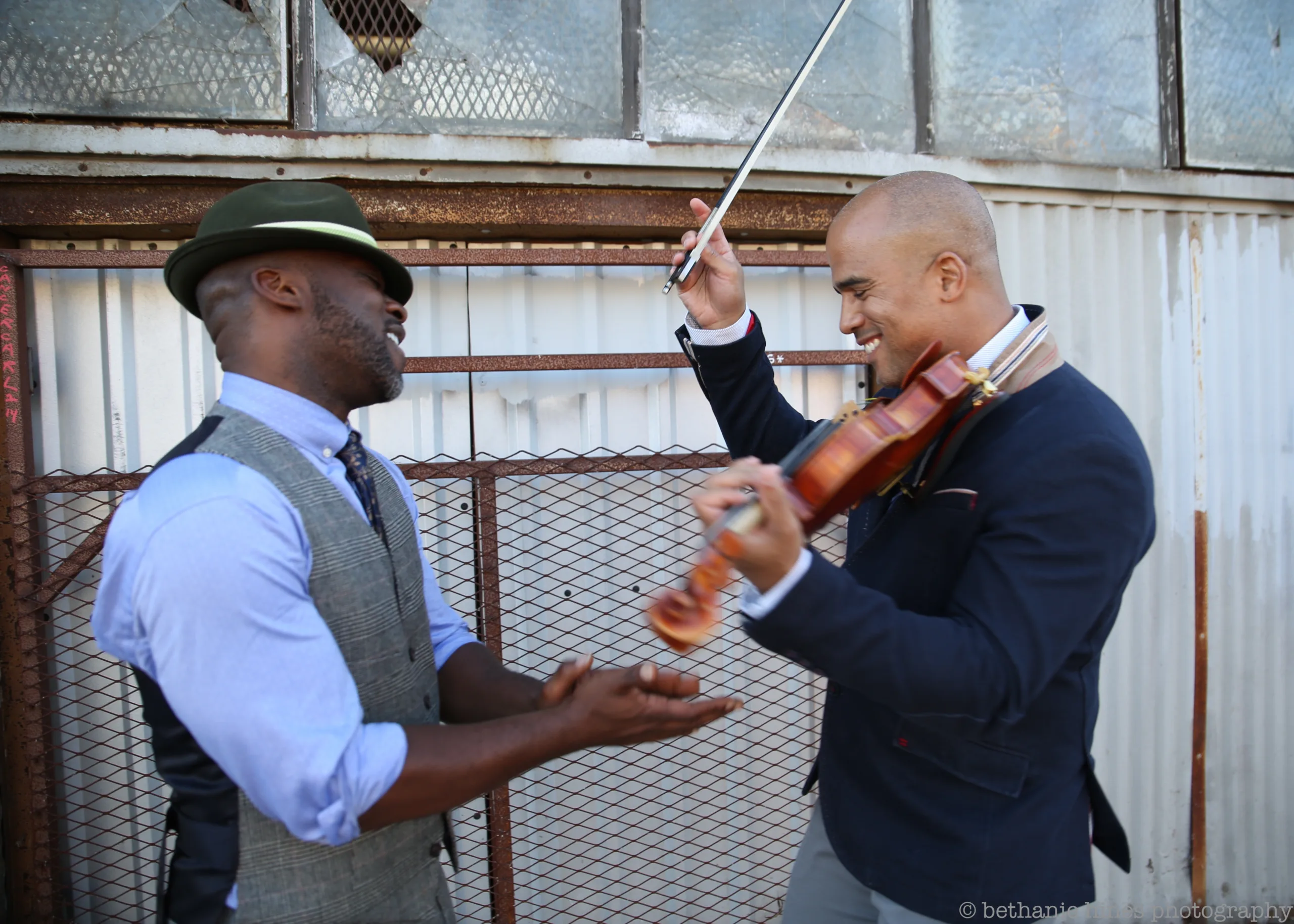 Bamuthi and DBR outside smiling with the violin.
