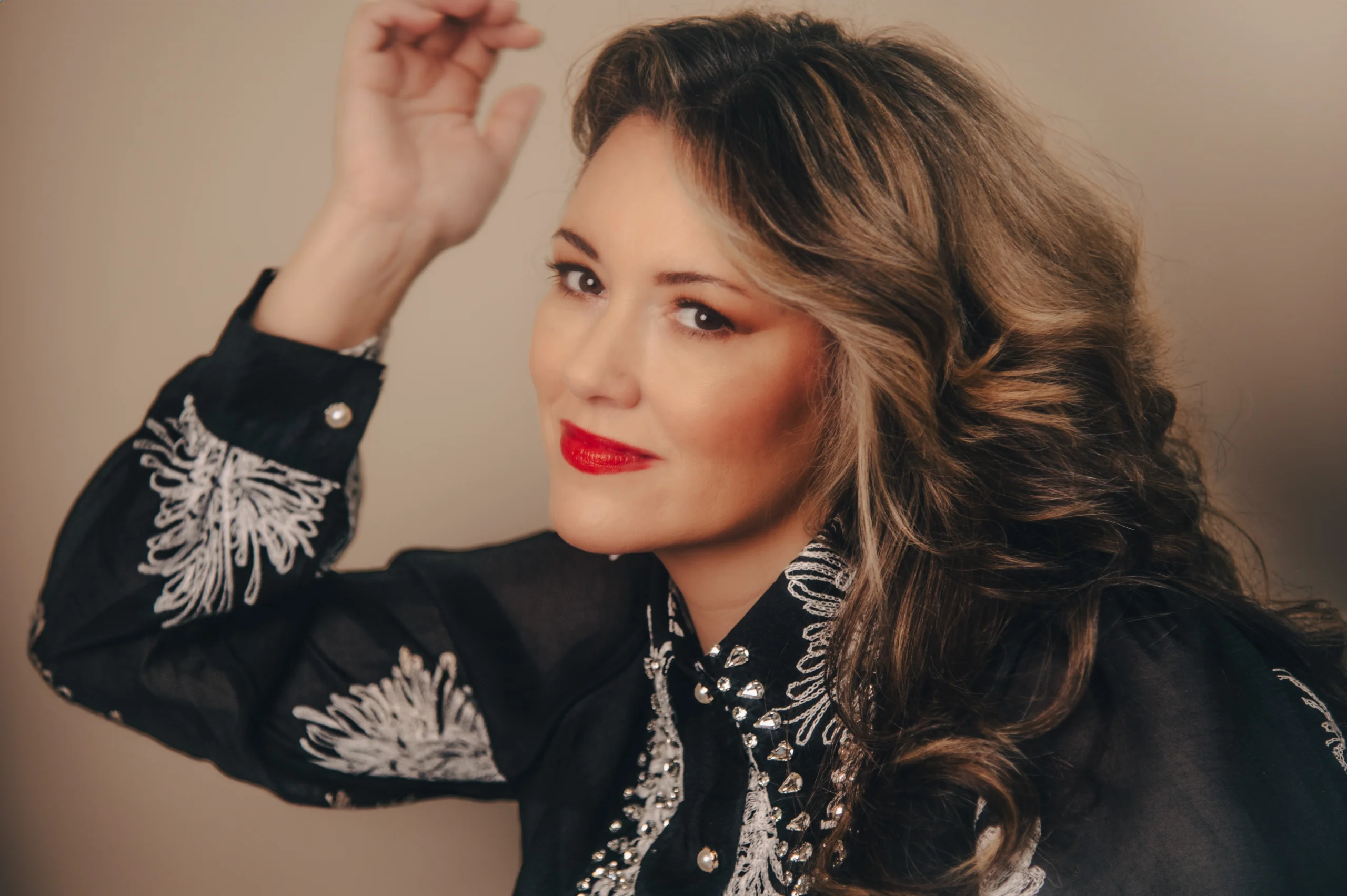 Mandy Barnett headshot wearing black and white shirt and red lipstick.