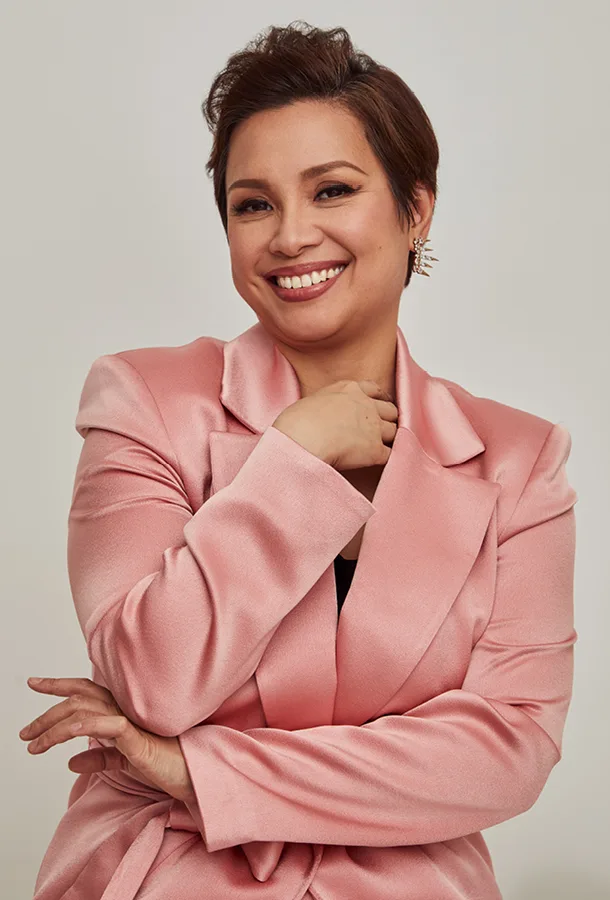 Headshot of Lea Salonga wearing a pink suit.