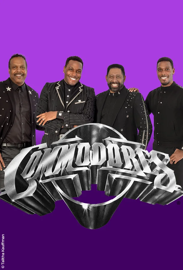 Four members of the Commodores in front of a bright purple background and the metallic silver Commodores logo in front.