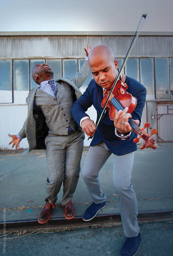 Bamuthi and DBR outside dancing with violin.