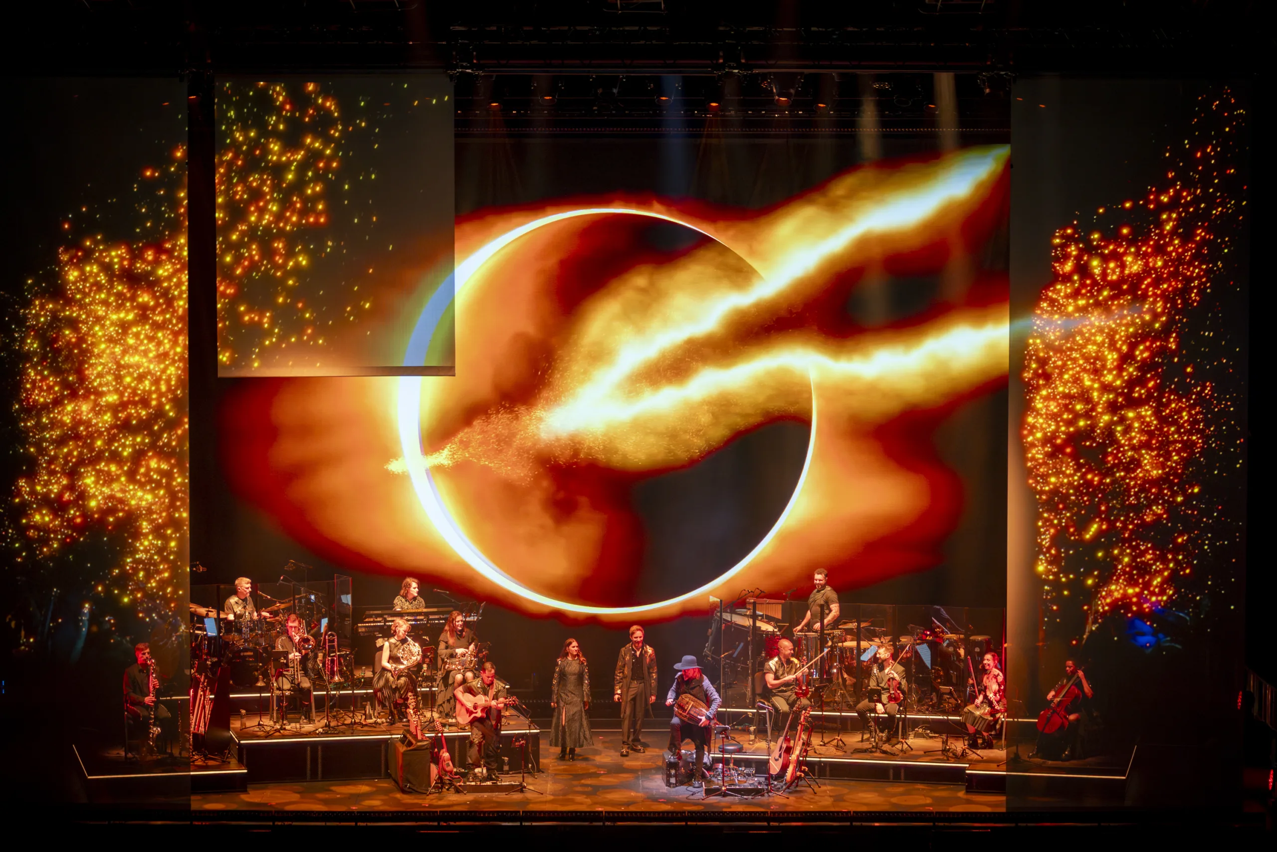 The band on stage with fiery orange light projections from 