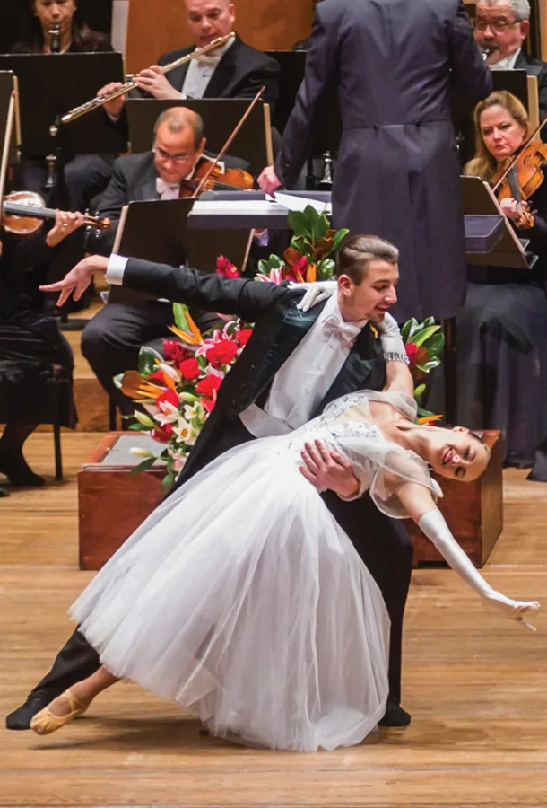 Ballroom dancers in pose in front of orchestra.