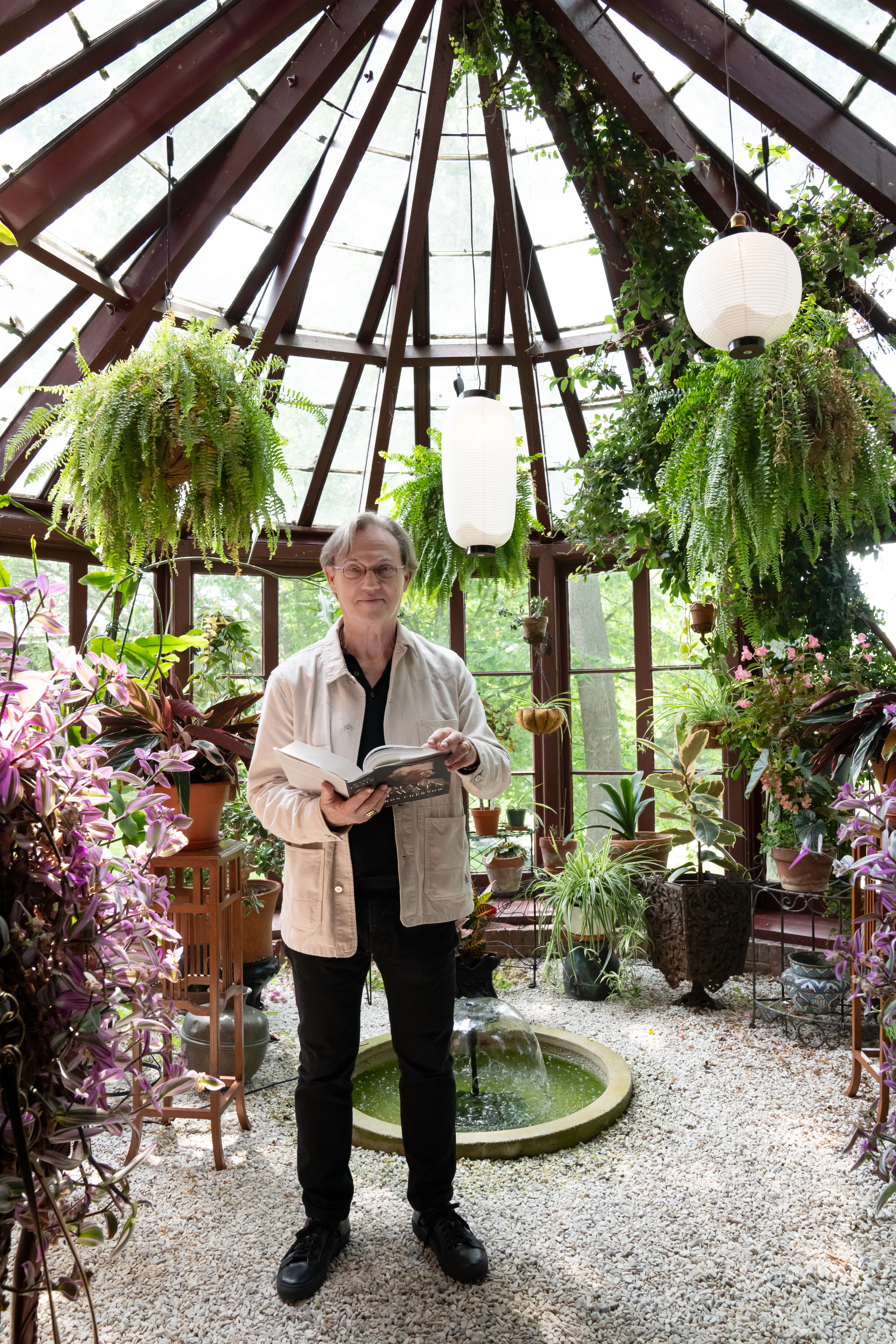 Photo of Richard Thomas holding book in solarium.