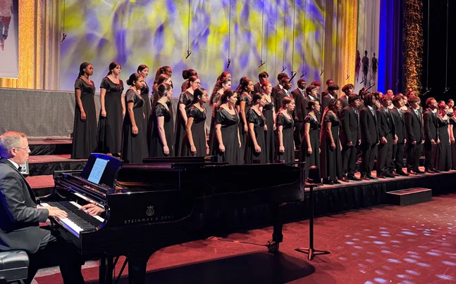Young Singers choir wearing black on stage singing.