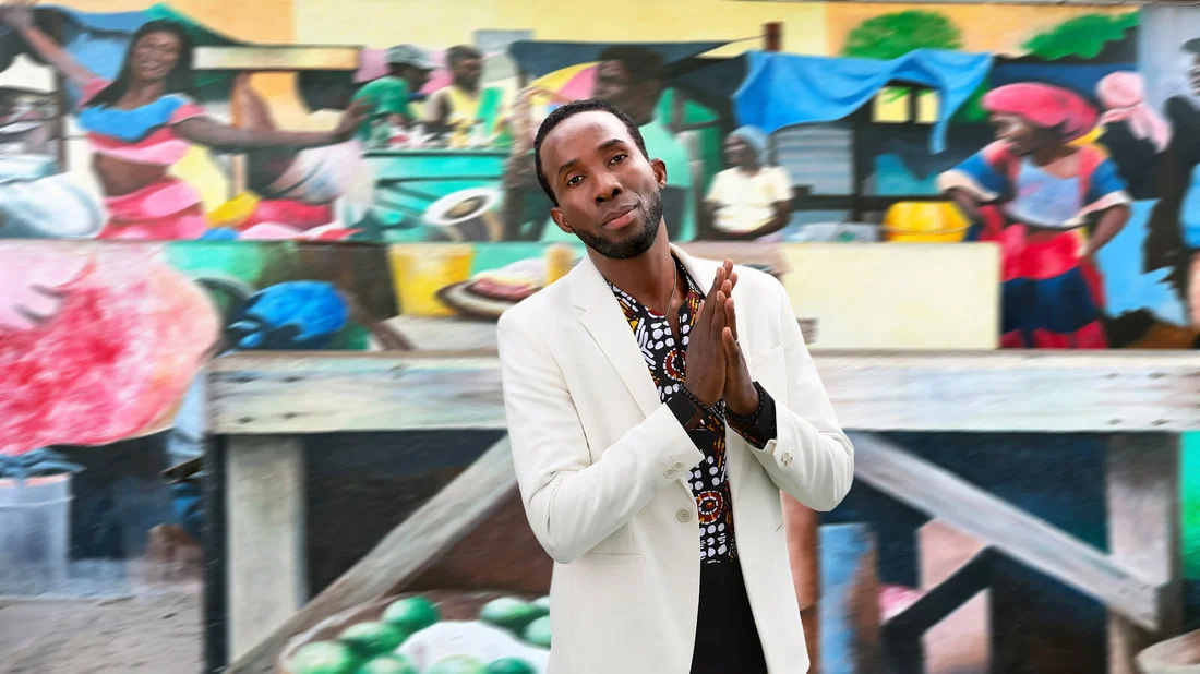 BélO posing in front of busy street mural.