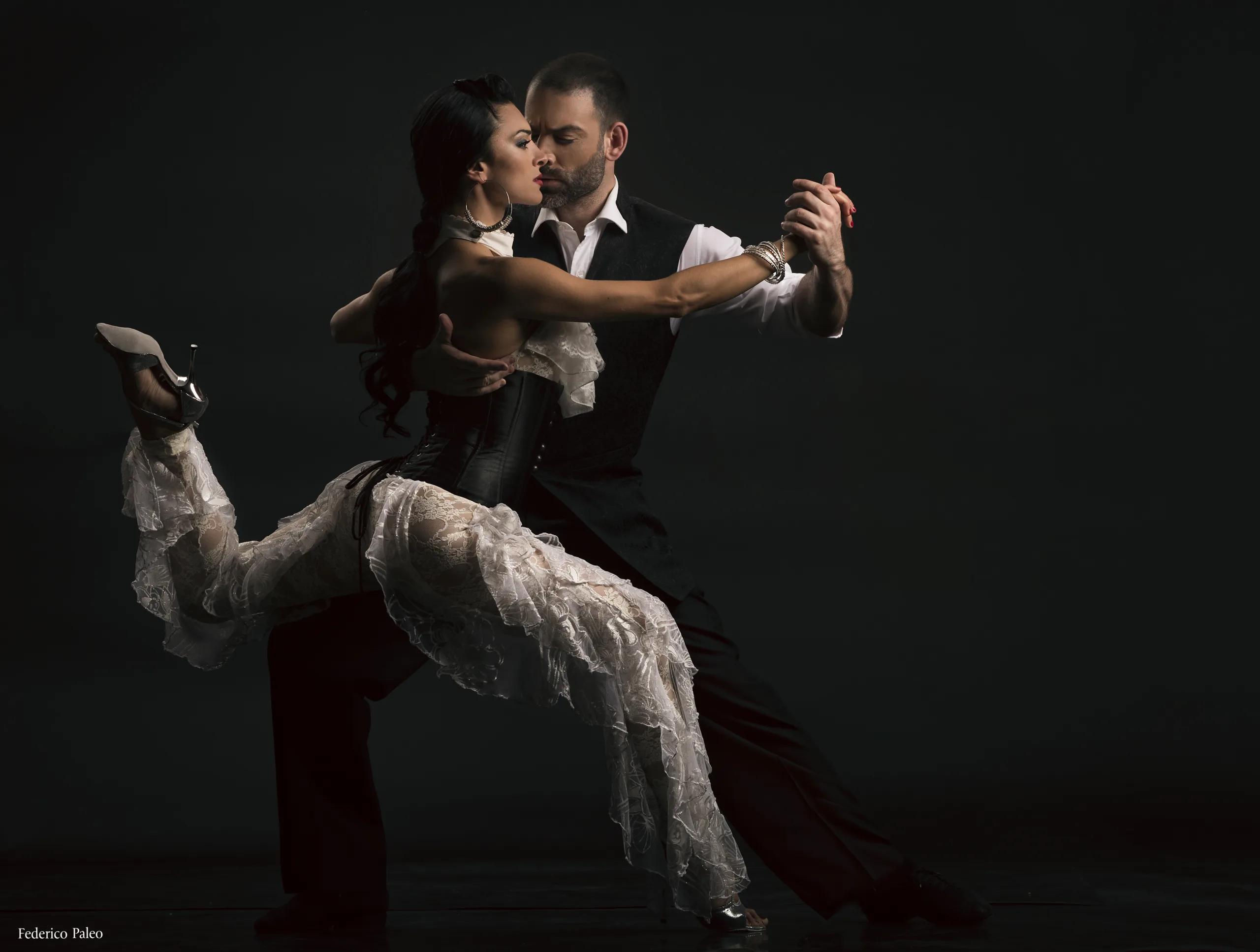 A man and a woman dancing tango in a close embrace.
