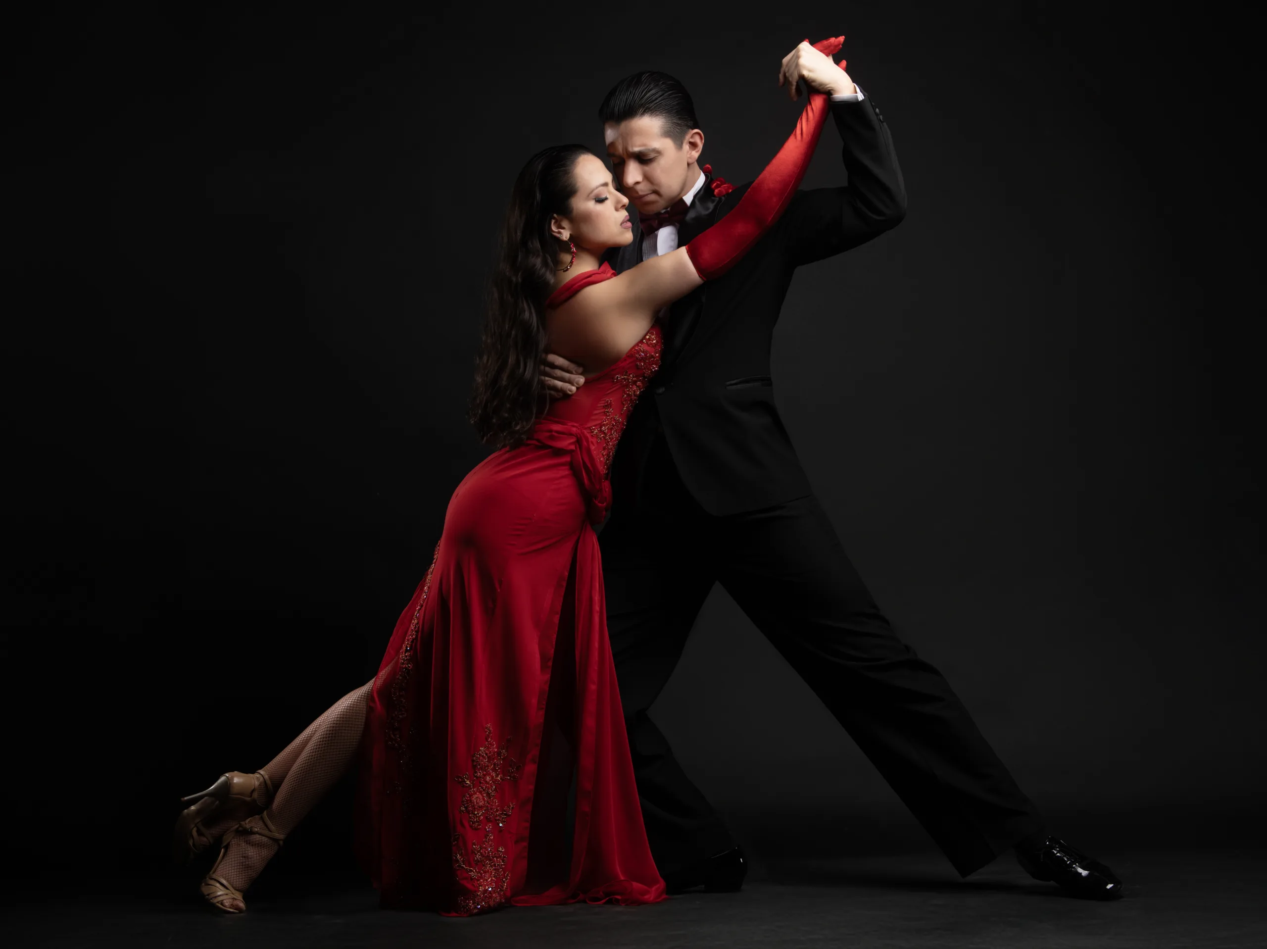 A man and a woman dancing tango in a close embrace.