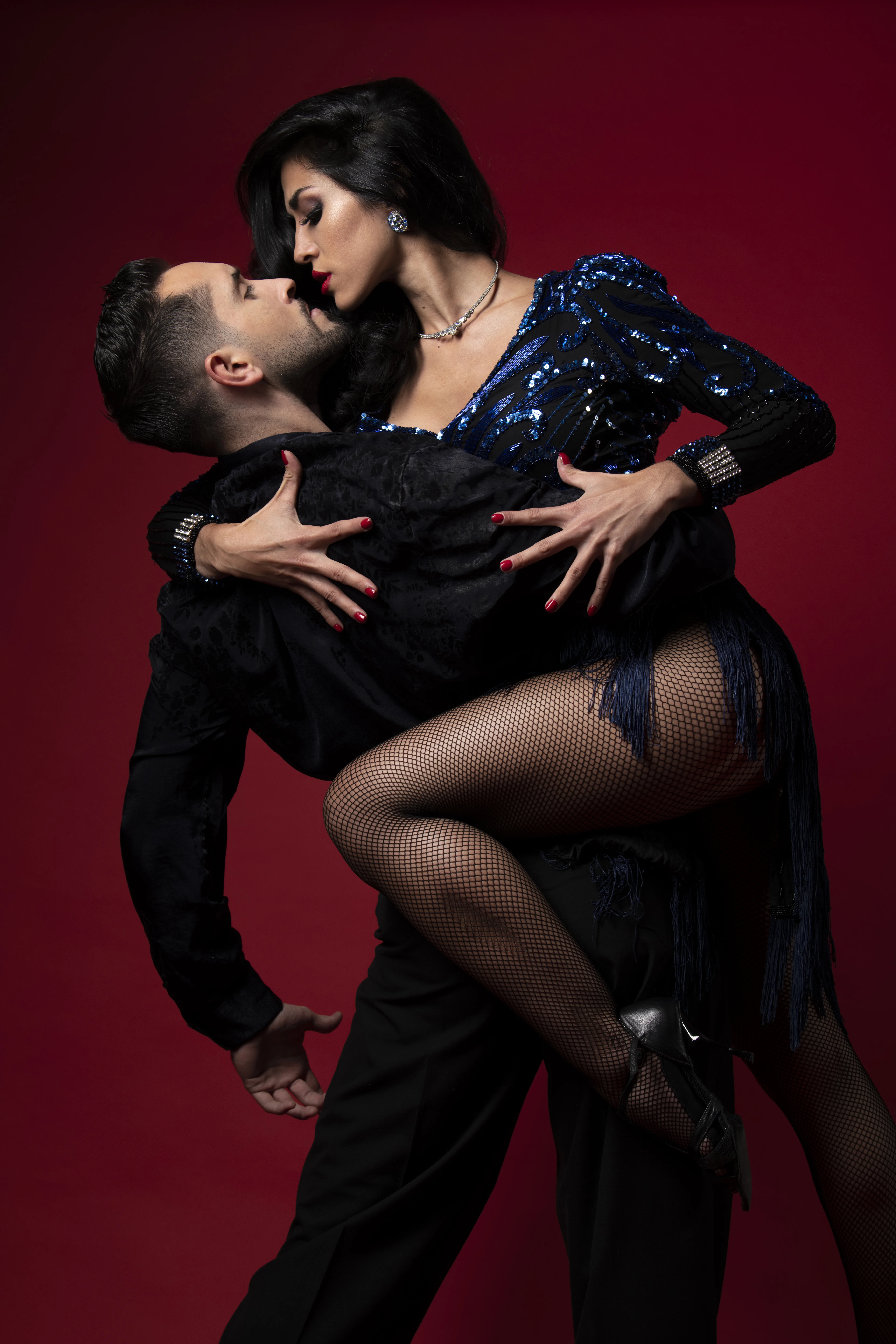 A man and a woman dancing tango in a close embrace.