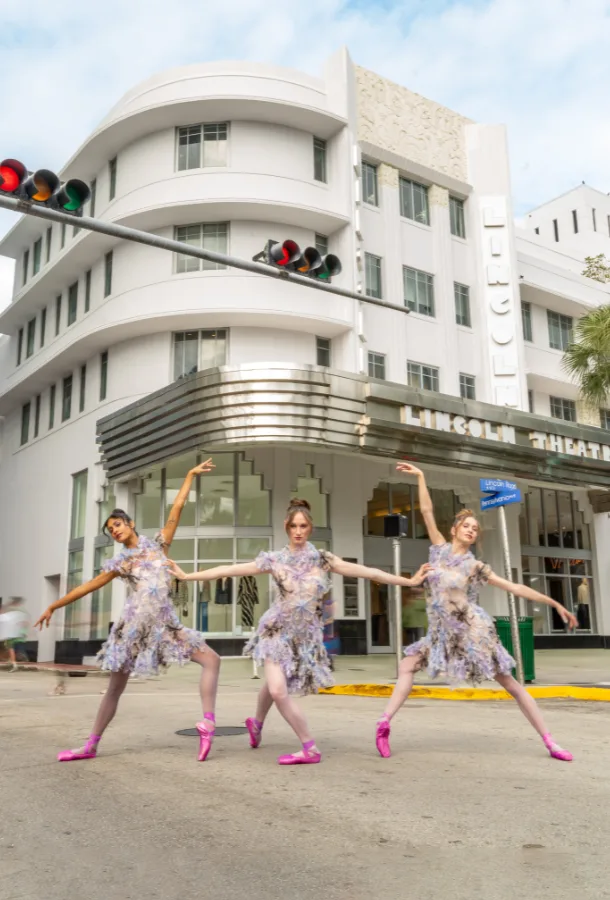 3 dancers in hot pink pointe shoes posing in front of a white building which says "Lincoln Theatre".