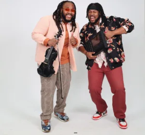 Two men holding their instruments and smiling