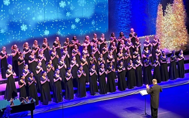 Young Singers choir wearing black on stage singing.