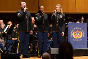 Three U.S. Army choir members singing in uniform