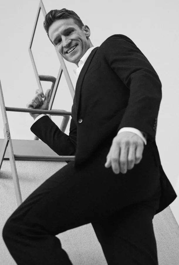 Claybourne Elder in black and white descending a ladder.