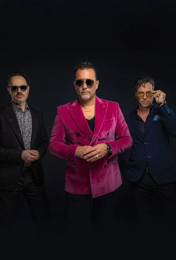 three men in various color suits wearing sunglasses