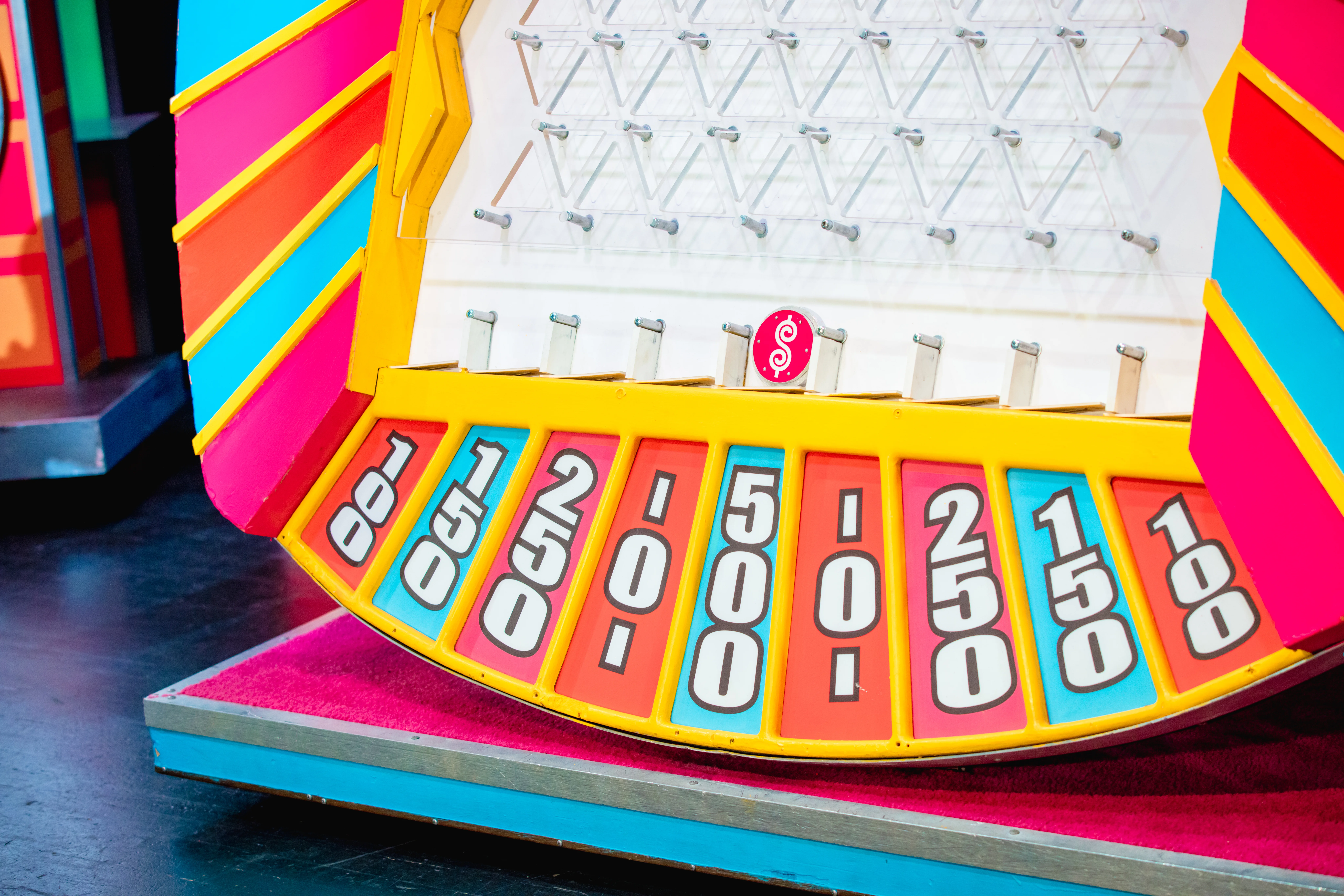 Game board resembling a Plinko setup with pegs and slots at the bottom labeled with point values: 100, 150, 200, 250, and 500.