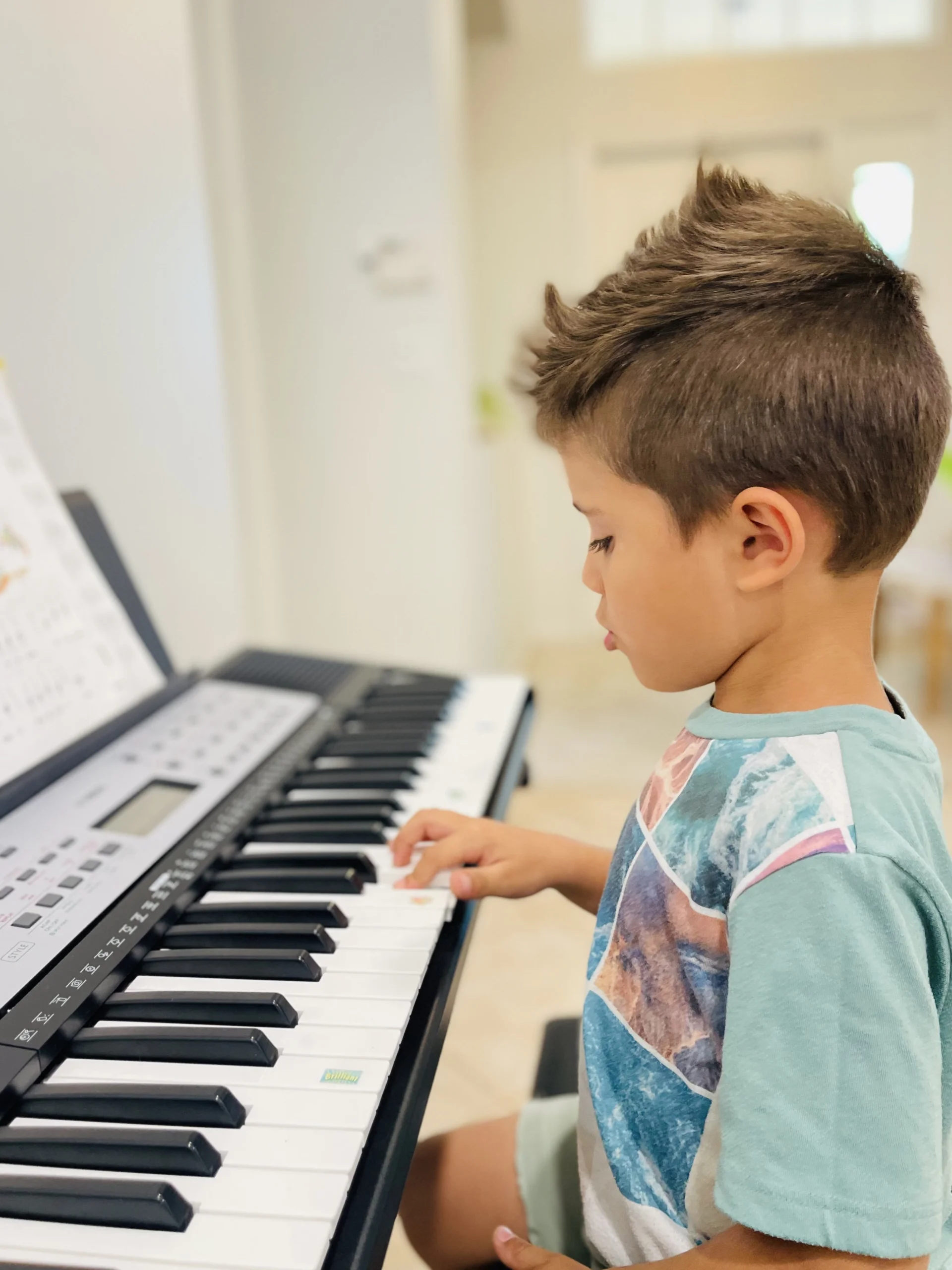 Young student playing piano in music studio.