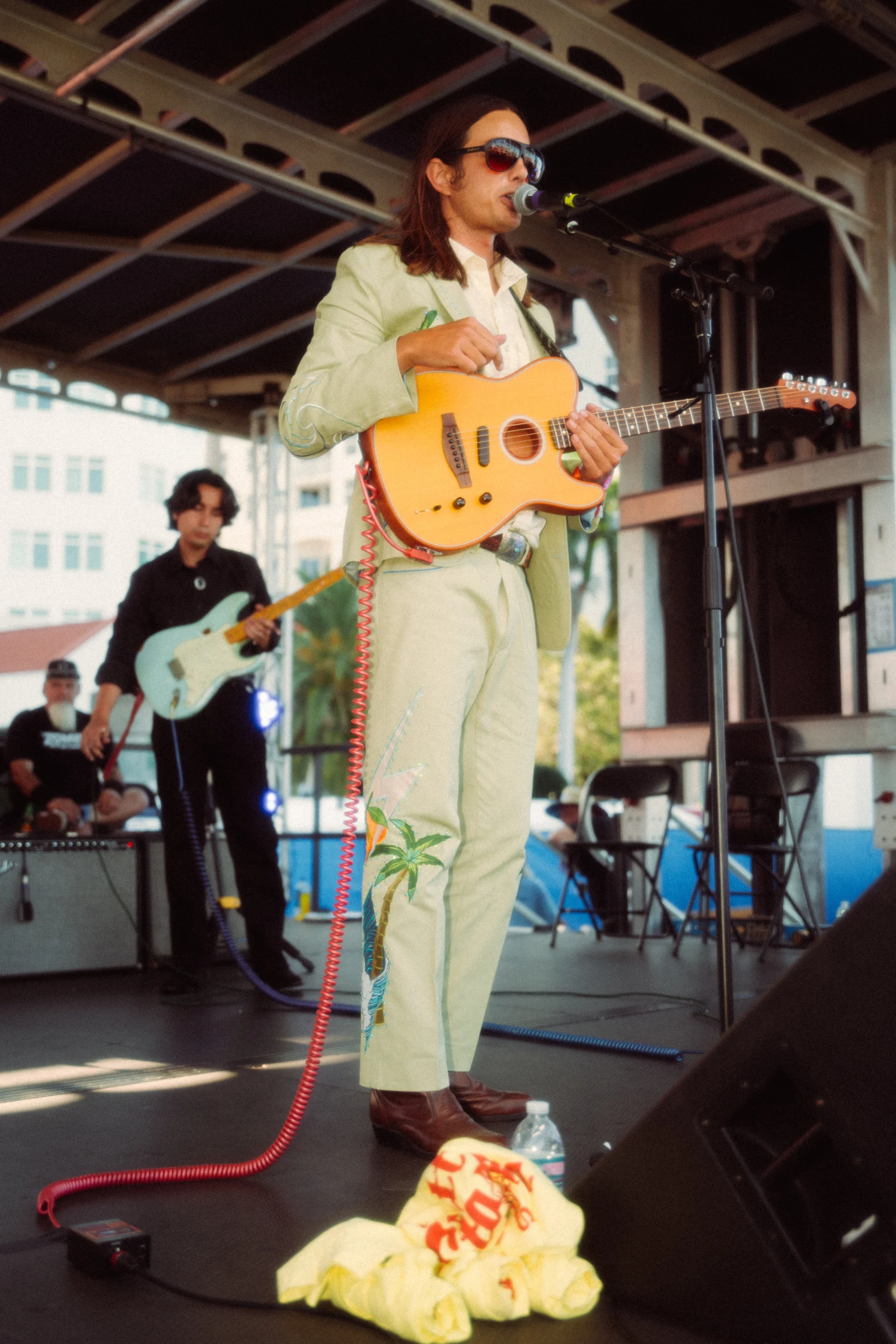 Brett Staska performing on stage with guitar singing.