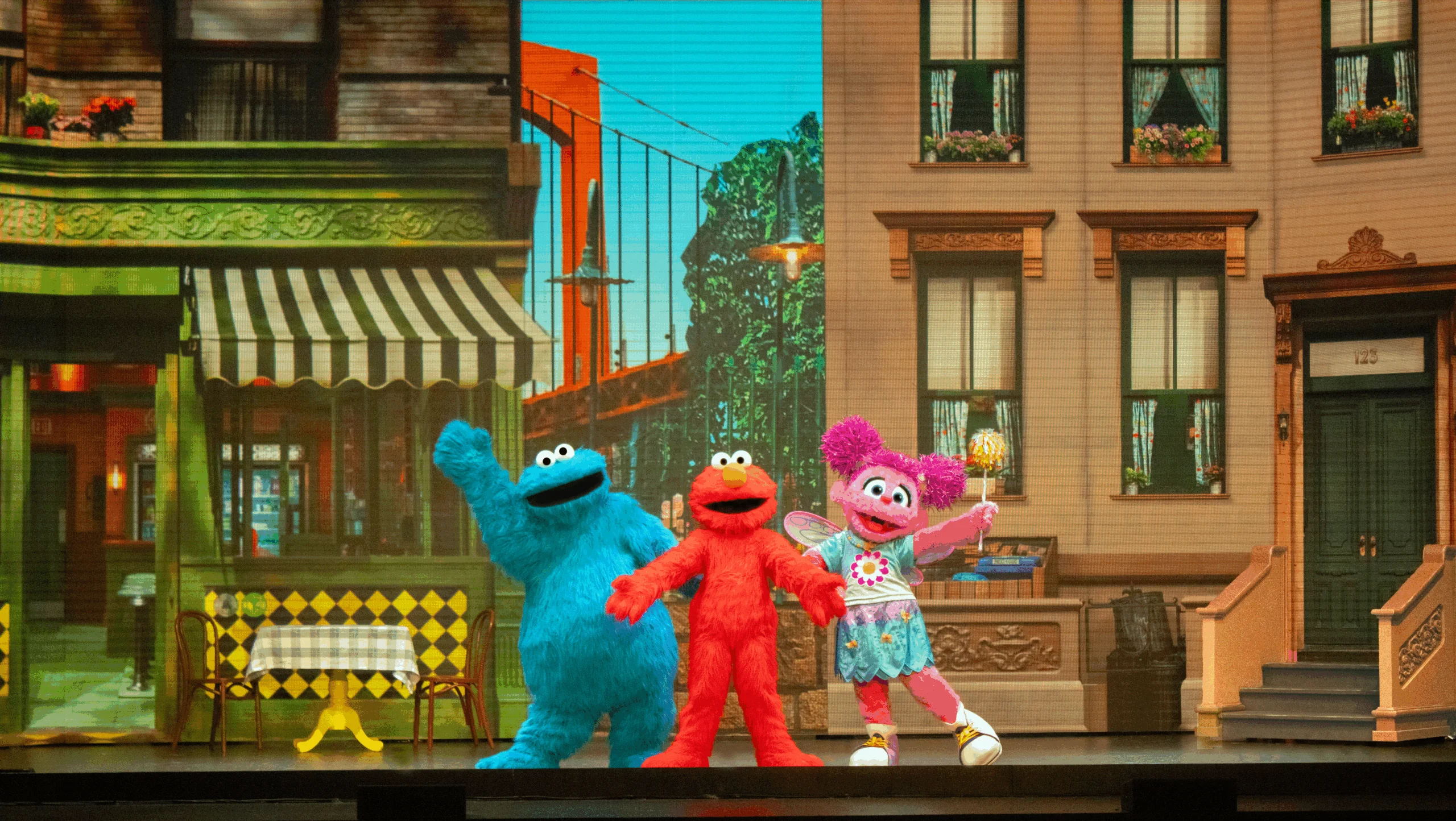 Cookie Monster, Elmo and Abby Cadabby wave to audience.
